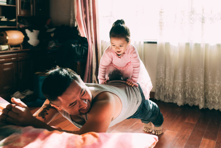 dad doing pushups with daughter